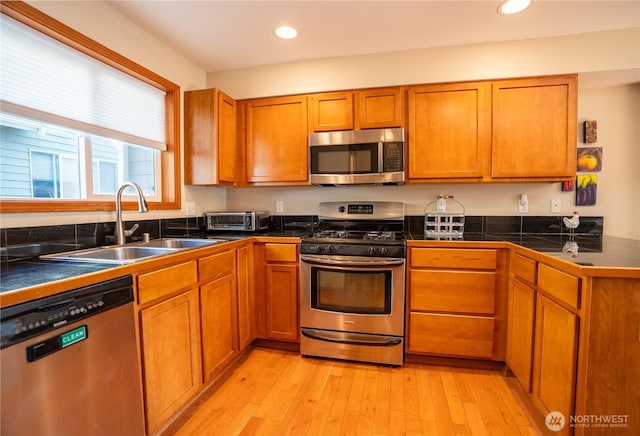 12723 35th Ave NE Unit B, Seattle, WA 98125 - kitchen featuring appliances with stainless steel finishes, brown cabinetry, light wood-style flooring, and recessed lighting