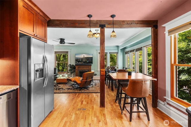 503 12th Ave E, Seattle, WA 98102 - dining room with a fireplace, light wood-type flooring, plenty of natural light, a ceiling fan, and beam ceiling