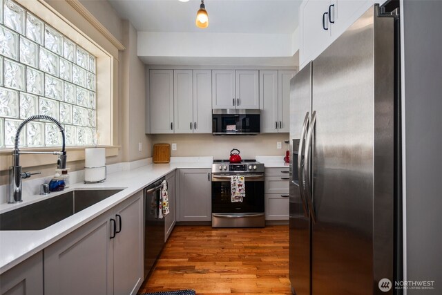 503 12th Ave E, Seattle, WA 98102 - kitchen with stainless steel appliances, gray cabinetry, and wood finished floors