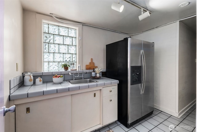 503 12th Ave E, Seattle, WA 98102 - kitchen featuring stainless steel fridge, tile counters, light tile patterned flooring, and white cabinetry