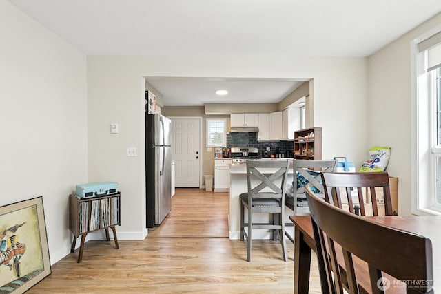 3827 Wetmore Ave, Everett, WA 98201 - kitchen featuring freestanding refrigerator, white cabinetry, light wood-style flooring, tasteful backsplash, and range