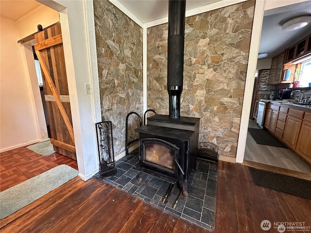 715 Copalis Beach Rd, Copalis Beach, WA 98535 - detailed view of a wood stove, a barn door, wood finished floors, and stainless steel dishwasher