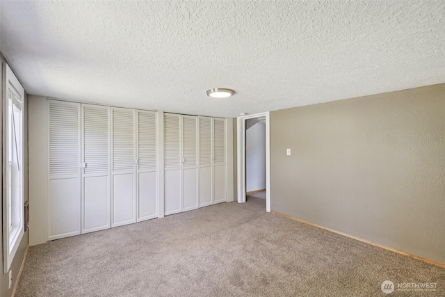 1425 N 1st Ave, Kelso, WA 98626 - unfurnished bedroom featuring carpet floors, two closets, and a textured ceiling