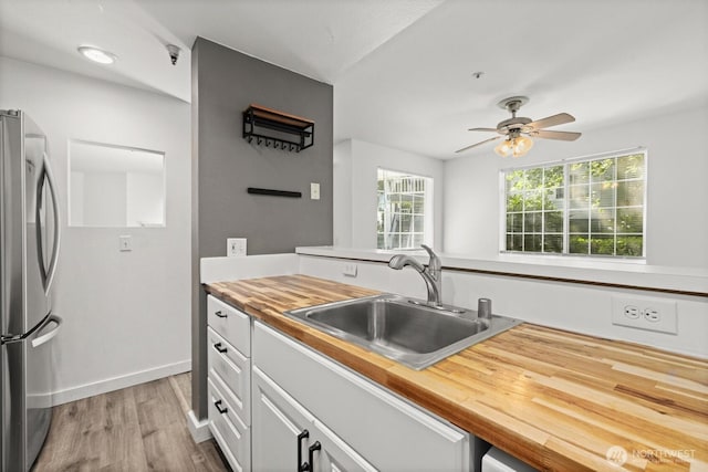 7453 Newcastle Golf Club Rd Unit L103, Newcastle, WA 98059 - kitchen featuring freestanding refrigerator, butcher block counters, light wood-style floors, a ceiling fan, and white cabinetry