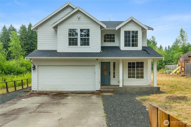 932 Tipsoo Loop N, Rainier, WA 98576 - traditional-style home with driveway, a garage, roof with shingles, and covered porch