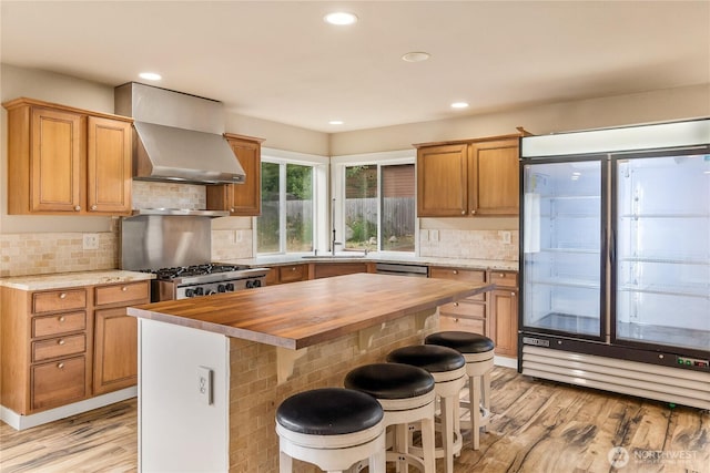 932 Tipsoo Loop N, Rainier, WA 98576 - kitchen with wooden counters, light wood-style floors, wall chimney range hood, recessed lighting, and tasteful backsplash