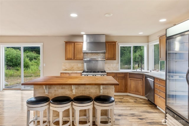 932 Tipsoo Loop N, Rainier, WA 98576 - kitchen with stainless steel appliances, wall chimney range hood, butcher block countertops, light wood-style flooring, and tasteful backsplash