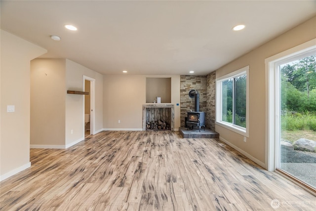 932 Tipsoo Loop N, Rainier, WA 98576 - unfurnished living room featuring a wood stove, wood finished floors, and recessed lighting