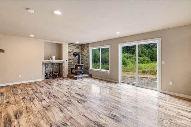 932 Tipsoo Loop N, Rainier, WA 98576 - unfurnished living room featuring wood finished floors, a wood stove, and recessed lighting