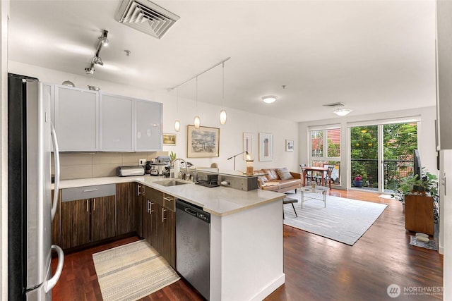 3104 Western Ave Unit 610, Seattle, WA 98121 - kitchen featuring appliances with stainless steel finishes, light countertops, a peninsula, dark wood-type flooring, and open floor plan