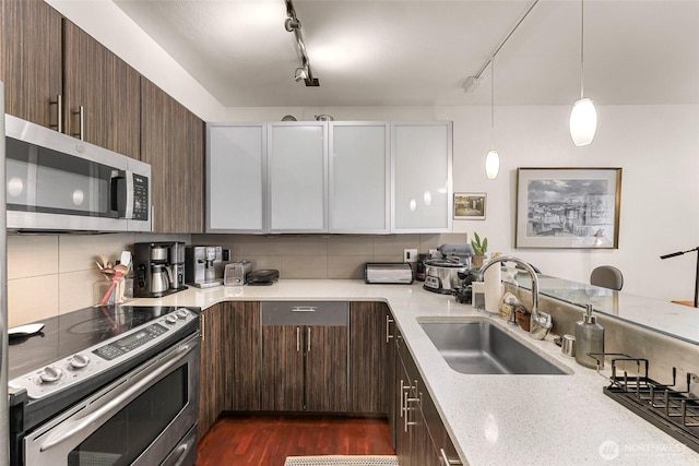 3104 Western Ave Unit 610, Seattle, WA 98121 - kitchen with appliances with stainless steel finishes, backsplash, rail lighting, and dark brown cabinetry