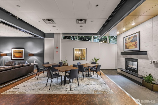3104 Western Ave Unit 610, Seattle, WA 98121 - dining room with a tiled fireplace, wood finished floors, and a paneled ceiling