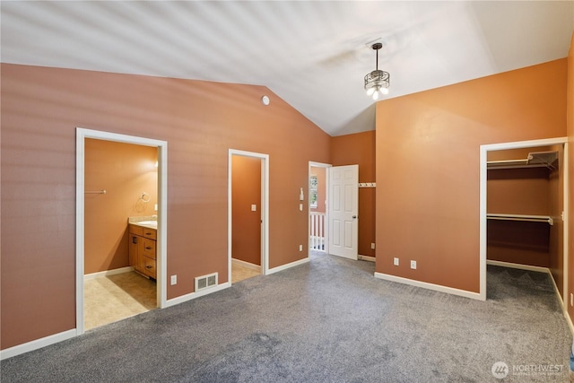 1229 14th St, Port Townsend, WA 98368 - unfurnished bedroom with a walk in closet, lofted ceiling, light colored carpet, ensuite bathroom, and a closet