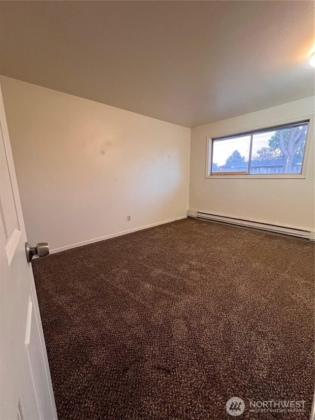 401 Biggs Dr, Moses Lake, WA 98837 - empty room featuring a baseboard heating unit and dark colored carpet