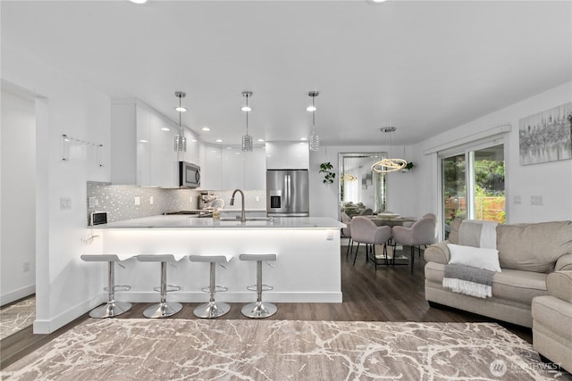 8254 Breeze Loop, Blaine, WA 98230 - kitchen with appliances with stainless steel finishes, white cabinets, open floor plan, a peninsula, and light countertops