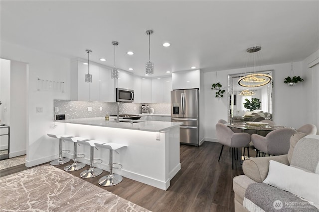 8254 Breeze Loop, Blaine, WA 98230 - kitchen featuring stainless steel appliances, a peninsula, white cabinetry, dark wood-type flooring, and light countertops