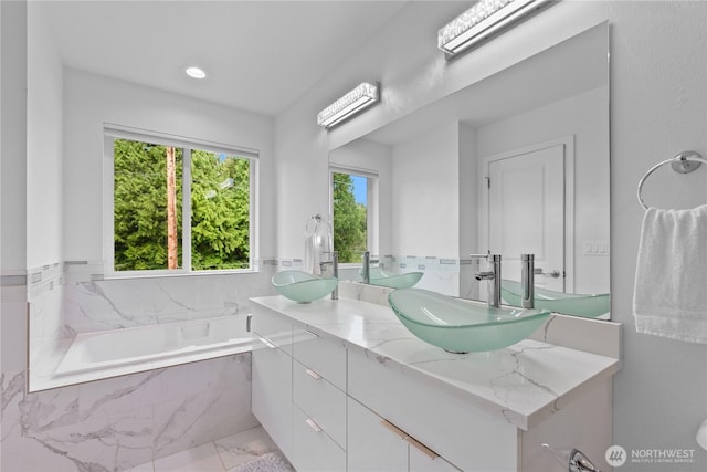 8254 Breeze Loop, Blaine, WA 98230 - full bathroom with double vanity, a garden tub, marble look tile flooring, and recessed lighting