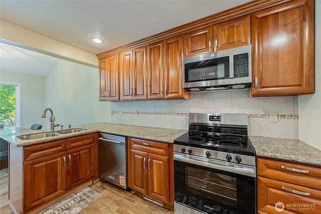 4164 Factoria Blvd SE Unit B11, Bellevue, WA 98006 - kitchen with stainless steel appliances, brown cabinets, light wood-style flooring, and a peninsula