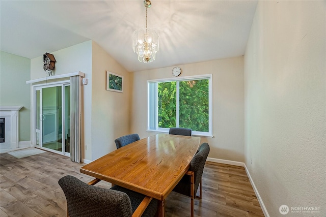 4164 Factoria Blvd SE Unit B11, Bellevue, WA 98006 - dining room with a chandelier, wood finished floors, vaulted ceiling, and a glass covered fireplace