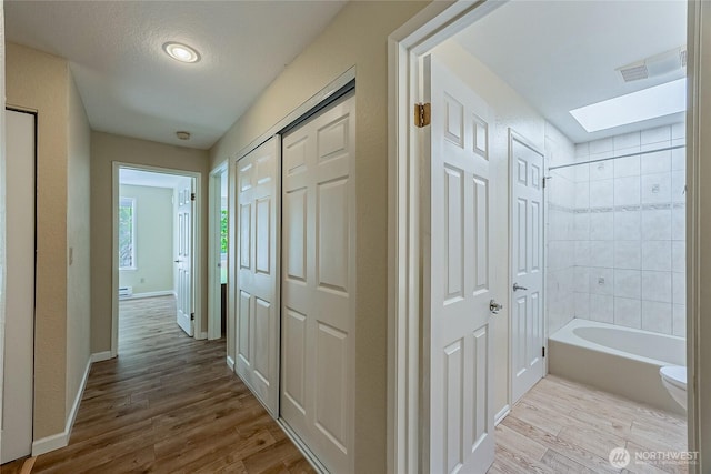 4164 Factoria Blvd SE Unit B11, Bellevue, WA 98006 - hallway with wood finished floors, a baseboard radiator, and a skylight