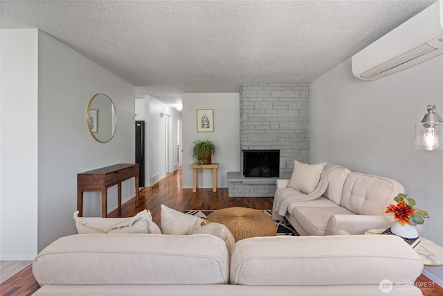 3317 N Baltimore St, Tacoma, WA 98407 - living room featuring an AC wall unit, a textured ceiling, wood finished floors, and a fireplace