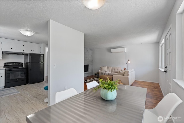 3317 N Baltimore St, Tacoma, WA 98407 - dining area with a wall mounted air conditioner, a textured ceiling, light wood-style flooring, and a fireplace