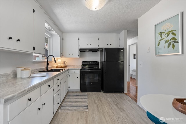 3317 N Baltimore St, Tacoma, WA 98407 - kitchen featuring black appliances, under cabinet range hood, light wood-type flooring, a textured ceiling, and white cabinetry