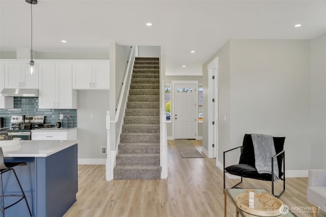 6410 S Fife St, Tacoma, WA 98409 - kitchen featuring stainless steel electric range, under cabinet range hood, white cabinetry, light countertops, and light wood-style floors