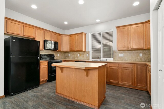 18214 97th Avenue Ct E, Puyallup, WA 98375 - kitchen featuring black appliances, light countertops, dark wood-style floors, tasteful backsplash, and a center island