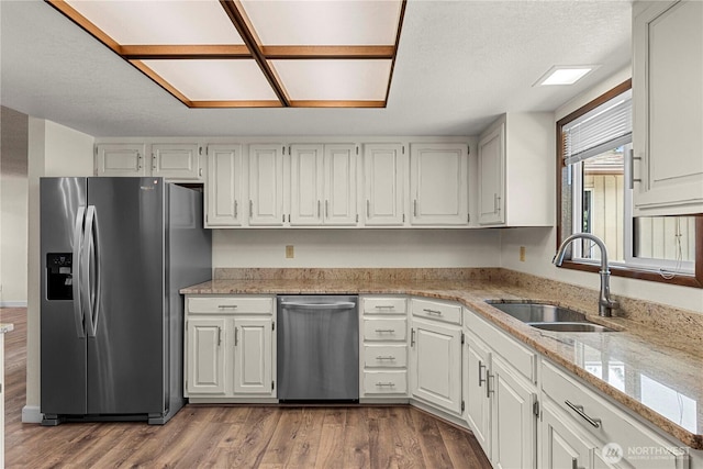 1201 Poe St, Wenatchee, WA 98801 - kitchen featuring appliances with stainless steel finishes, wood finished floors, white cabinetry, and light stone counters