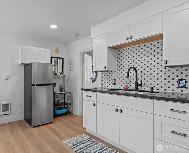 1027 E 47th St, Tacoma, WA 98404 - kitchen featuring freestanding refrigerator, dark countertops, and tasteful backsplash