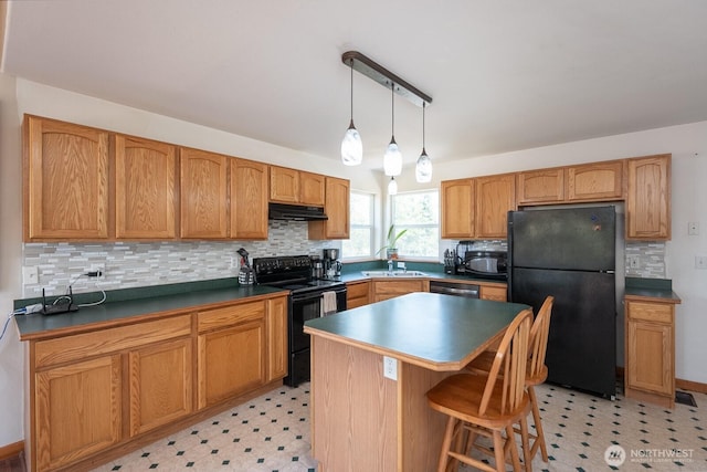 2207 W Depot Springs Rd, Spangle, WA 99031 - kitchen with black appliances, light floors, backsplash, a kitchen bar, and pendant lighting