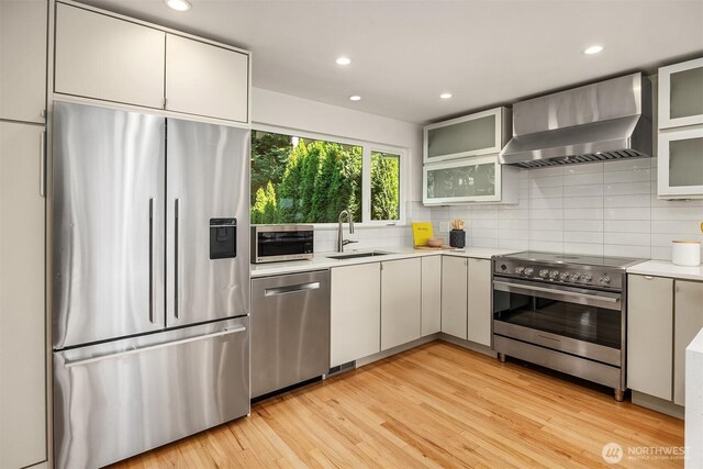 2434 64th Ave SE, Mercer Island, WA 98040 - kitchen with stainless steel appliances, wall chimney range hood, light countertops, decorative backsplash, and recessed lighting