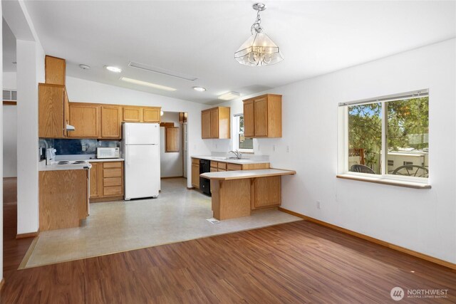 101 Twin Lakes Rd, Cle Elum, WA 98922 - kitchen with freestanding refrigerator, light countertops, vaulted ceiling, a peninsula, and brown cabinets