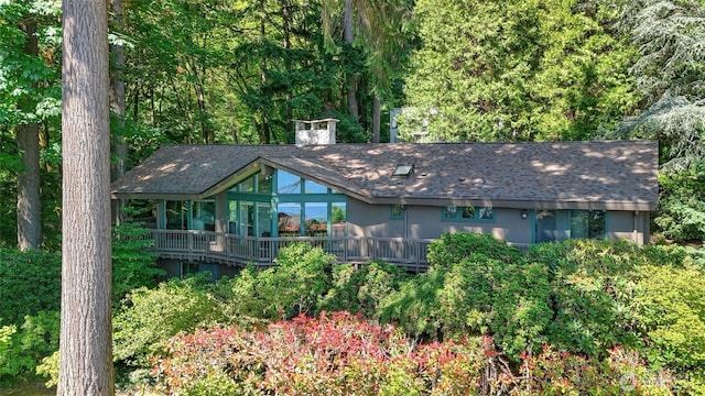 9411 SE 54th St, Mercer Island, WA 98040 - view of front of house featuring a sunroom, a shingled roof, and a deck