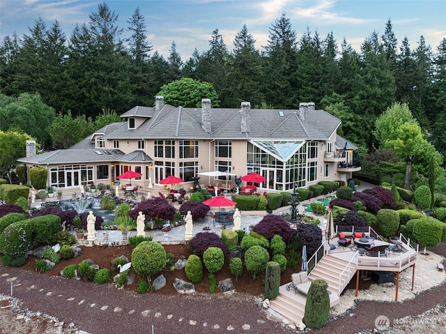1022 7th Ct, Fox Island, WA 98333 - rear view of property featuring a chimney, outdoor dining area, a patio area, and stairs