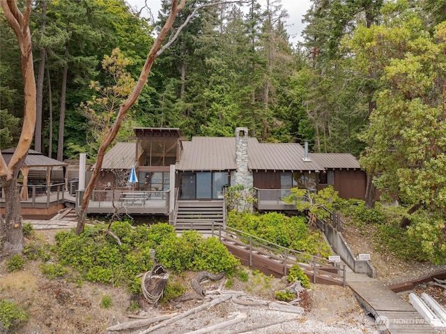 69 Rocky Rd, Crane Island, WA 98245 - view of front of home with a metal roof, a gazebo, a wooden deck, a chimney, and stairway