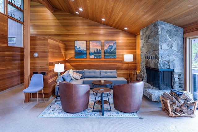 69 Rocky Rd, Crane Island, WA 98245 - living room featuring vaulted ceiling, wooden walls, wooden ceiling, a stone fireplace, and carpet