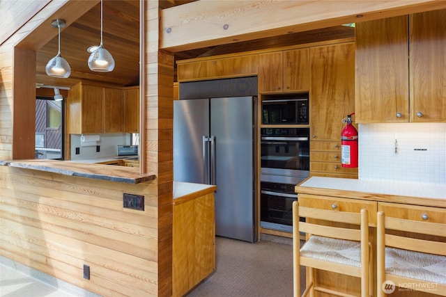 69 Rocky Rd, Crane Island, WA 98245 - kitchen featuring high end fridge, double wall oven, black microwave, tasteful backsplash, and brown cabinetry