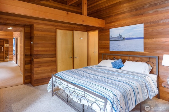 69 Rocky Rd, Crane Island, WA 98245 - bedroom with wooden walls, carpet floors, a wooden ceiling with exposed beams, a closet, and a water view
