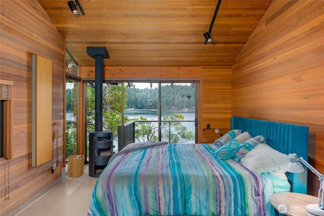 69 Rocky Rd, Crane Island, WA 98245 - bedroom with lofted ceiling, wood walls, track lighting, wood ceiling, and a wood stove