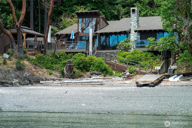 69 Rocky Rd, Crane Island, WA 98245 - view of front of home featuring a chimney, a metal roof, and a standing seam roof