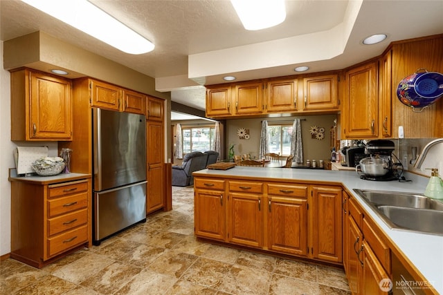 1130 Central Dr, Coulee Dam, WA 99116 - kitchen featuring freestanding refrigerator, brown cabinets, a peninsula, light countertops, and recessed lighting