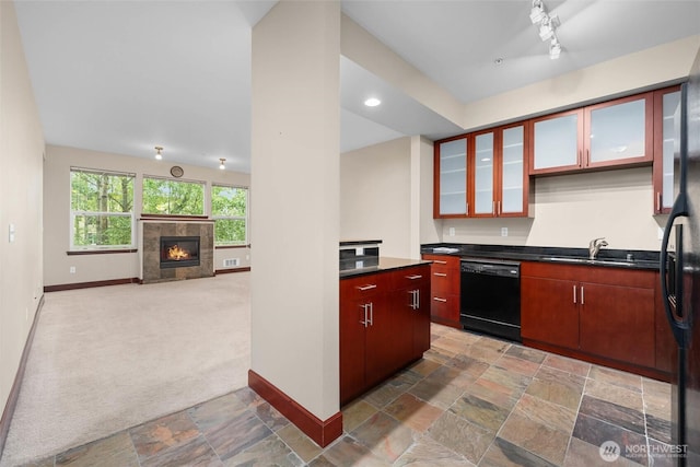 259 W Bakerview Unit 304, Bellingham, WA 98226 - kitchen featuring dishwasher, dark countertops, stone tile floors, light carpet, and a tiled fireplace