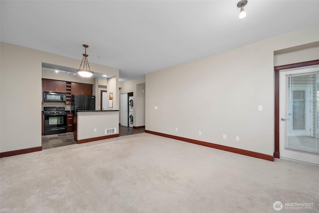 259 W Bakerview Unit 304, Bellingham, WA 98226 - unfurnished living room with stacked washer / drying machine and carpet flooring