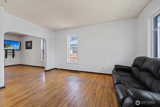 524 E 9th Ave, Spokane, WA 99202 - living area featuring arched walkways, light wood-style flooring, and a textured ceiling