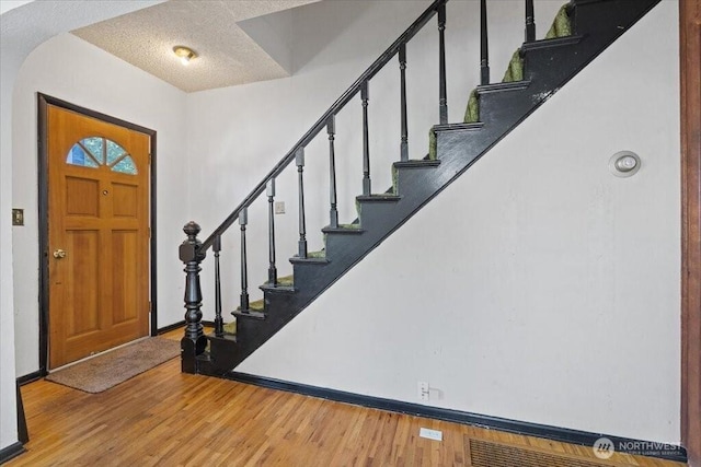 524 E 9th Ave, Spokane, WA 99202 - entryway featuring light wood-type flooring, arched walkways, stairs, and a textured ceiling
