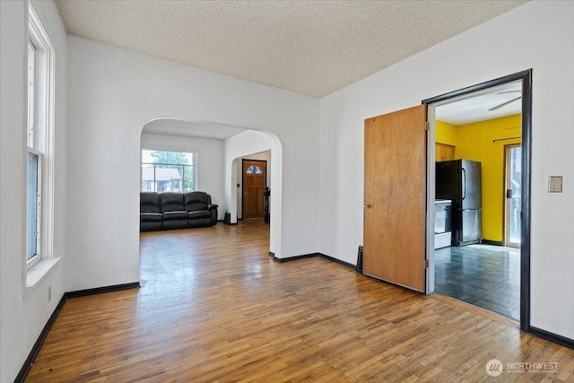 524 E 9th Ave, Spokane, WA 99202 - spare room with arched walkways, light wood-type flooring, and a textured ceiling