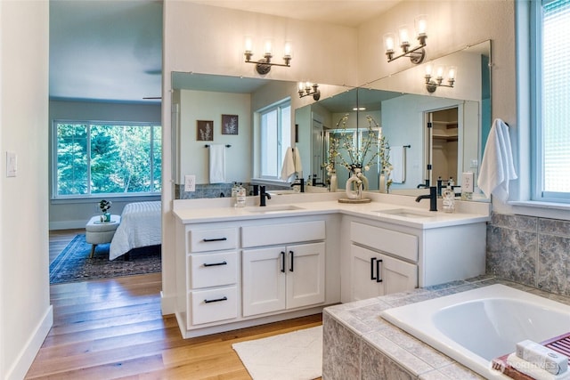 4957 Lewis Ave, Bellingham, WA 98229 - full bathroom with double vanity, a bath, a chandelier, and wood finished floors