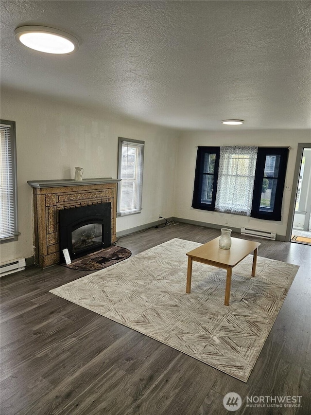 3023 Aberdeen Ave, Hoquiam, WA 98550 - living area with a baseboard radiator, a textured ceiling, a fireplace with flush hearth, and wood finished floors